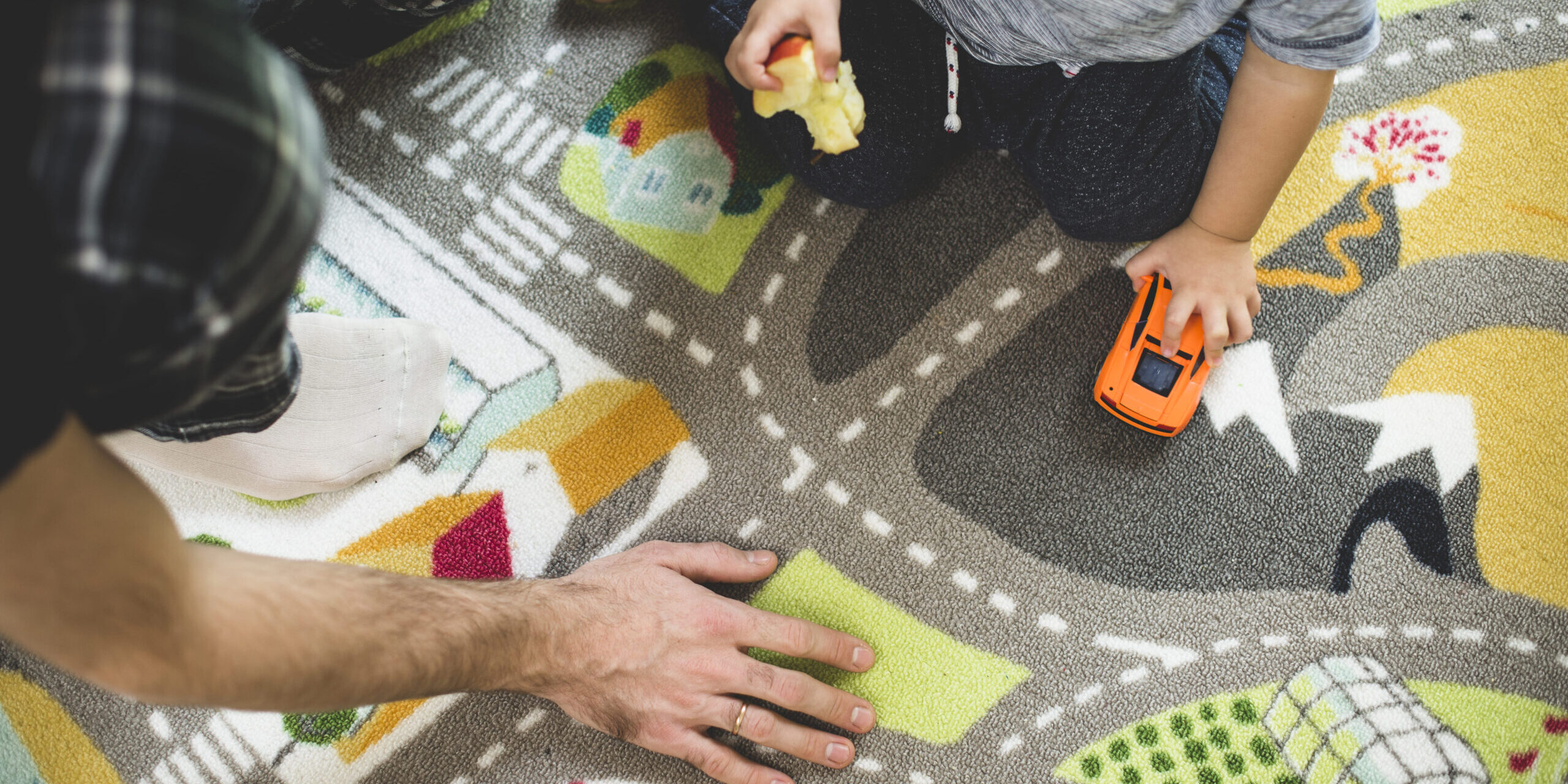 educación infantil bilingüe en valencia – niño comiendo manzana y jugando coche