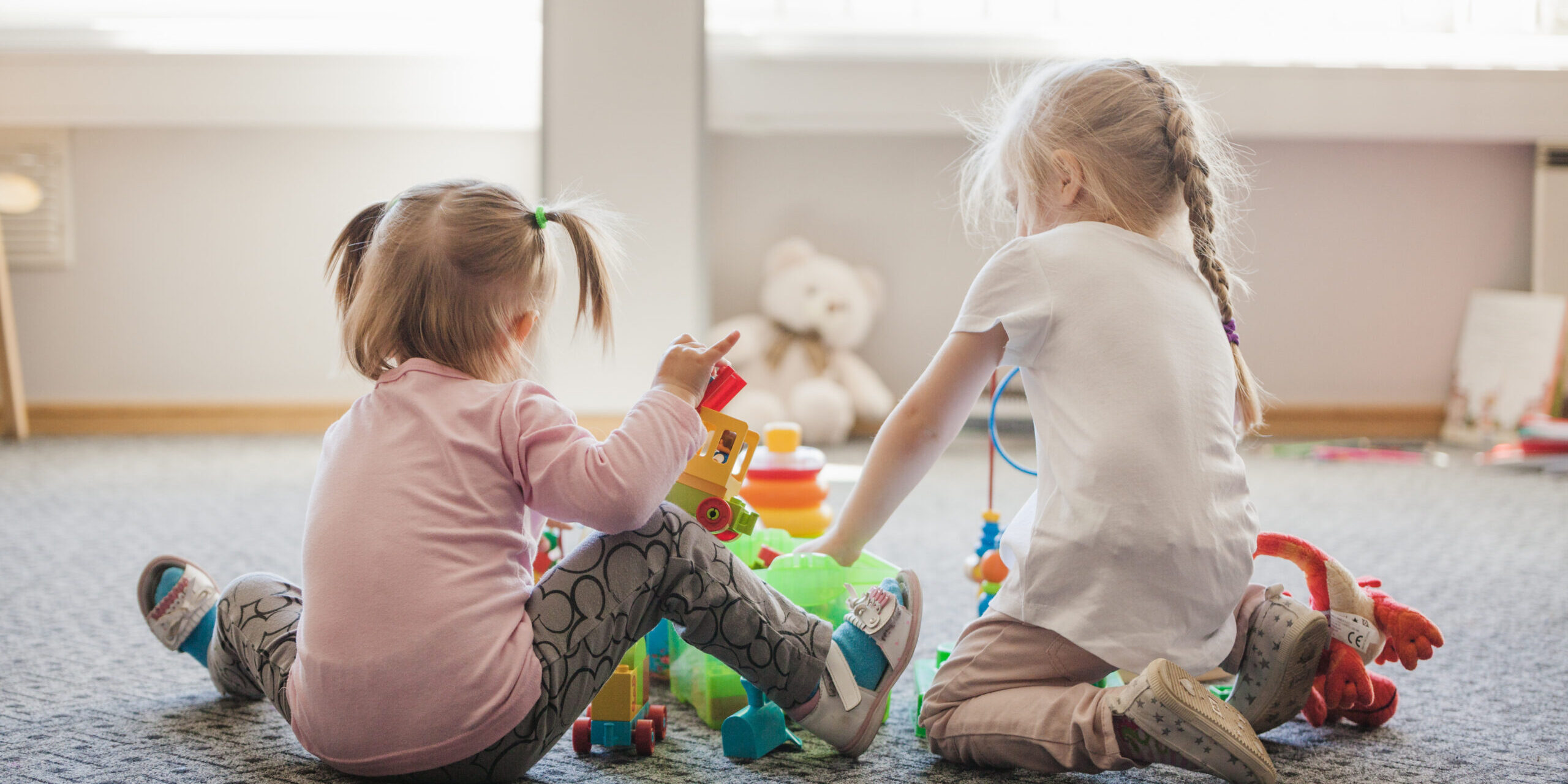 two-little-girls-sitting-floor-playing centro de educacion infantil en valencia - niñas jugando